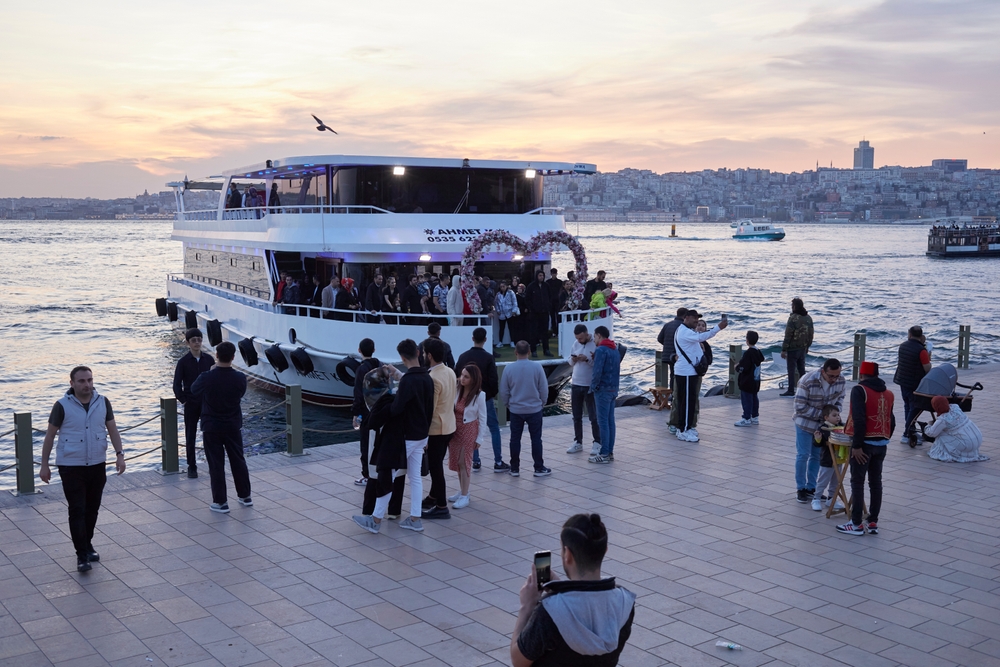 Guests boarding a Bosphorus dinner cruise boat at the pier in Istanbul at night